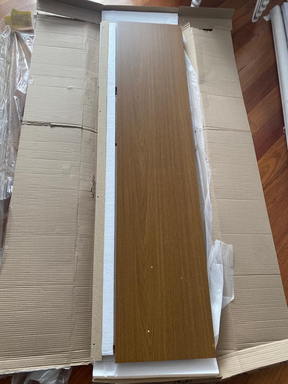 Piezas de un mueble de TV color madera antes de iniciar el armado